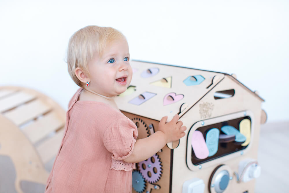 A girl playing with the wooden house