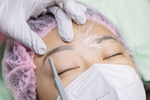 Woman getting her eyebrows done with permanent makeup