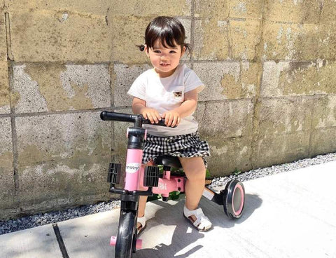 a toddler rides a tricycle