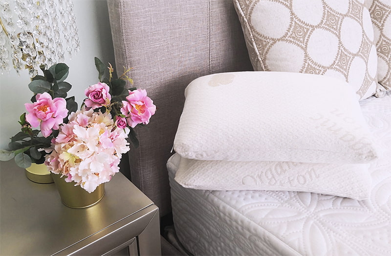 Two Sweet Zzz buckwheat pillows on a bed on top of each other.