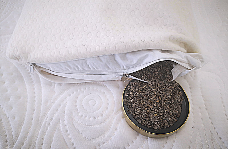 Zipper of the Sweet Zzz buckwheat pillow is open and showing the buckwheat hulls inside