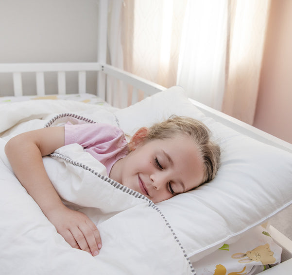 child sleeping in bed with cooling pillow