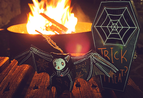 Halloween bat and halloween coffin in front of a fire