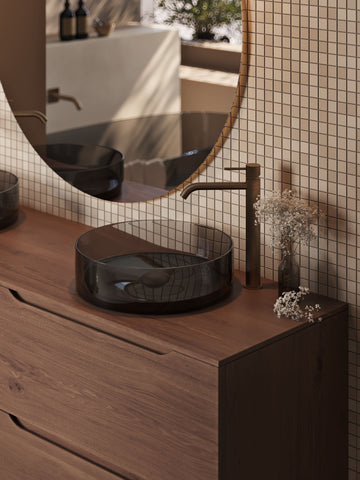Design badkamer met mooie tegels, kranen en doorzichtige wasbak