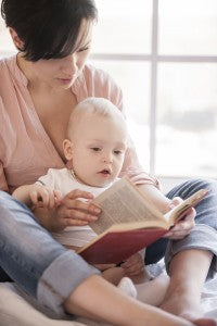 Little bookworm. Young mother holding baby and reading a book