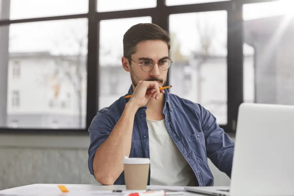 middle aged man looking at his laptop and working with coffee