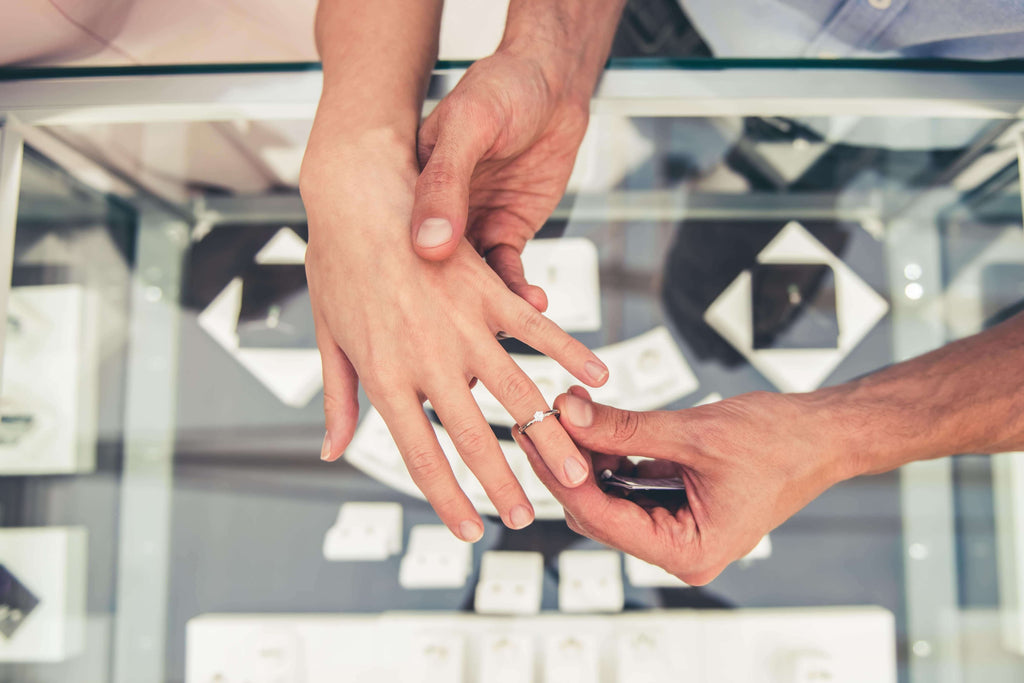 Man and woman trying on different diamond baguette engagement rings