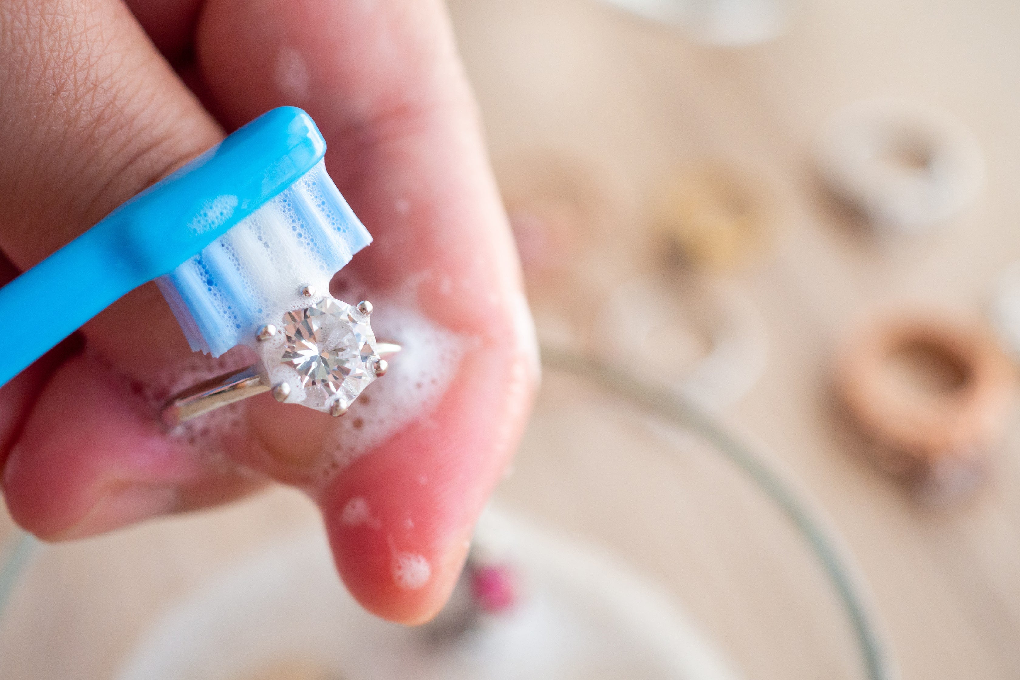 using soap and water to clean diamond with a toothbrush