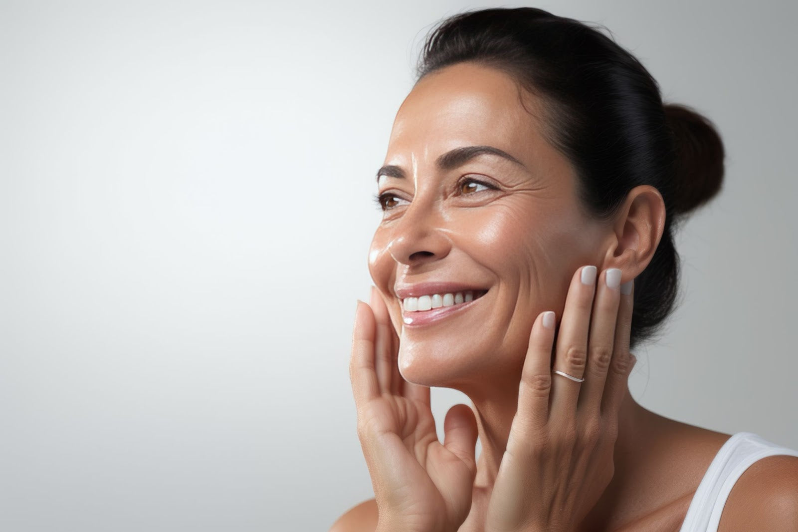 A woman smiling and applying face cream, emphasizing skincare routine and products