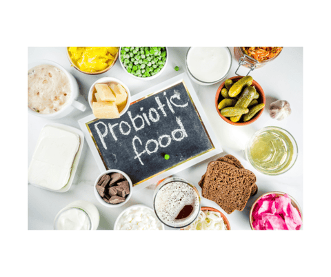 An assortment of probiotic food items on a white background with a blackboard in the center
