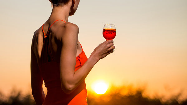 Woman at sunset enjoying a low calorie, low carb & sugar free cocktail made with Sobreo cocktail mix