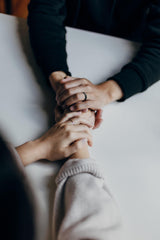 Two people holding hands for support