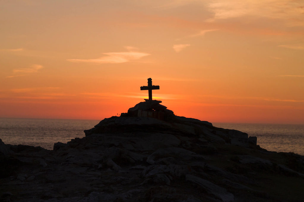 Cross on a rock pile at sunset