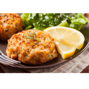 image of crab cake with lemon and greens as a garnish