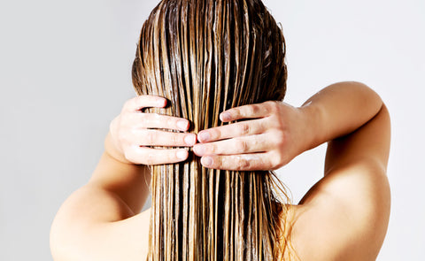 Woman Applying Coconut Oil On Hair