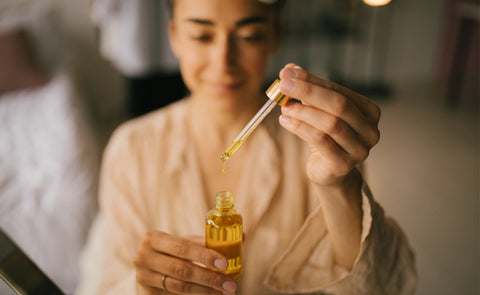 Woman Holding Bottle Of Face Oil