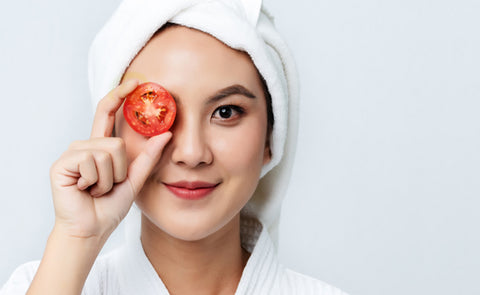 Woman Holding Tomato On Face