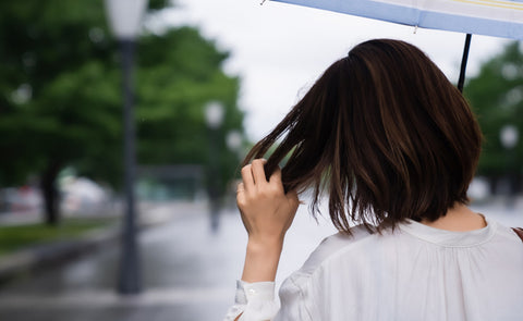 Woman Holding An Umbrella Worried About Her Hair