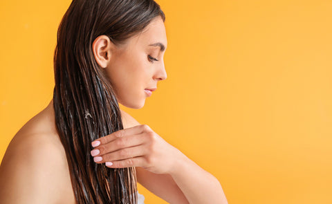 Woman Applying Coconut Oil On Hair