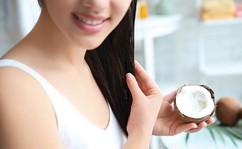 Woman applying virgin coconut oil on hair Woman Applying Oil On Hair