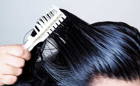 woman combing oily hair