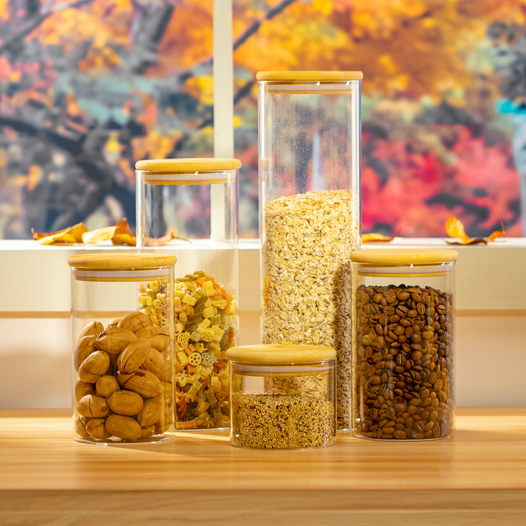 genicook's glass canisters filled with nuts and oats surrounded by fall leaves