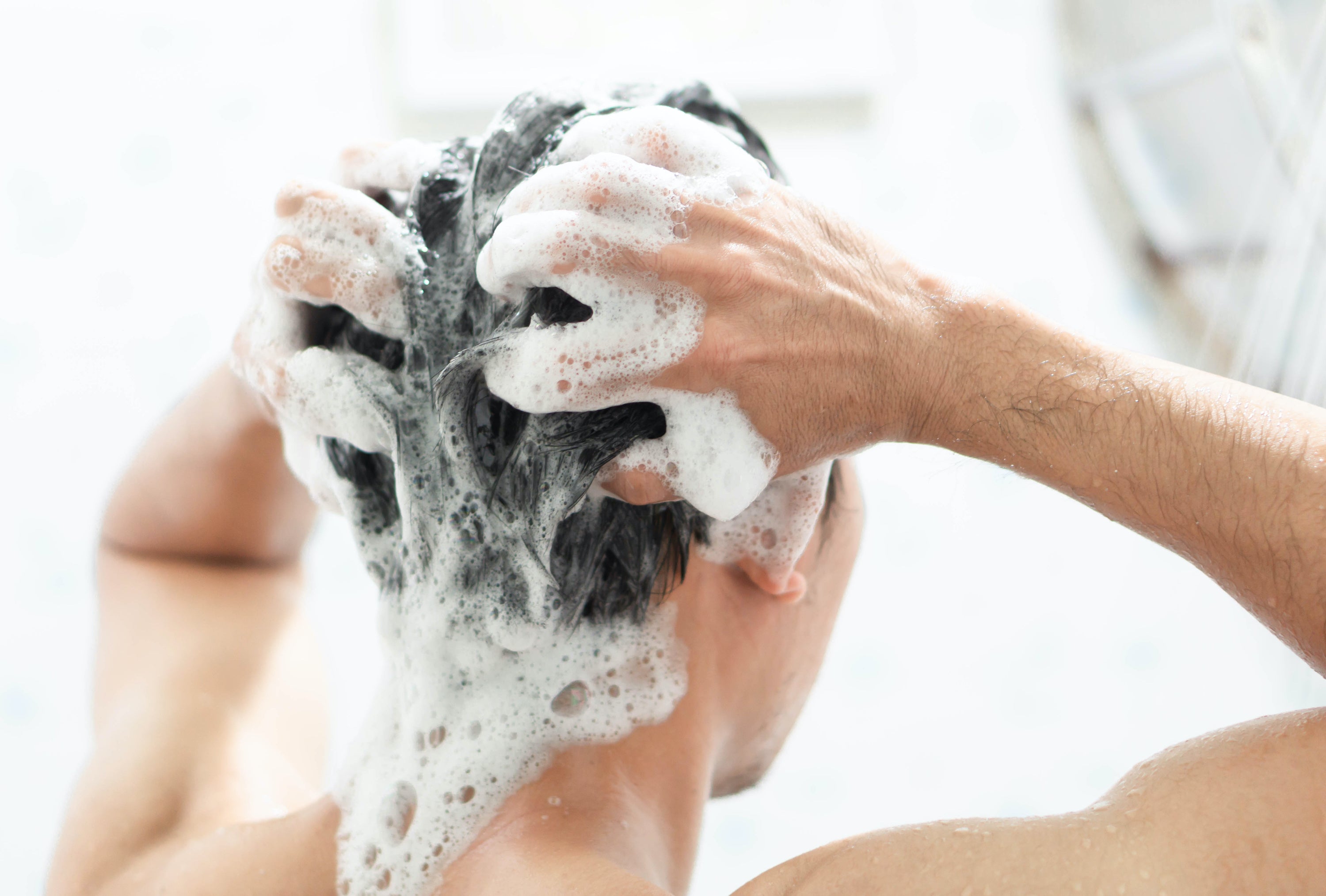 woman washing hair with natural shampoo bar