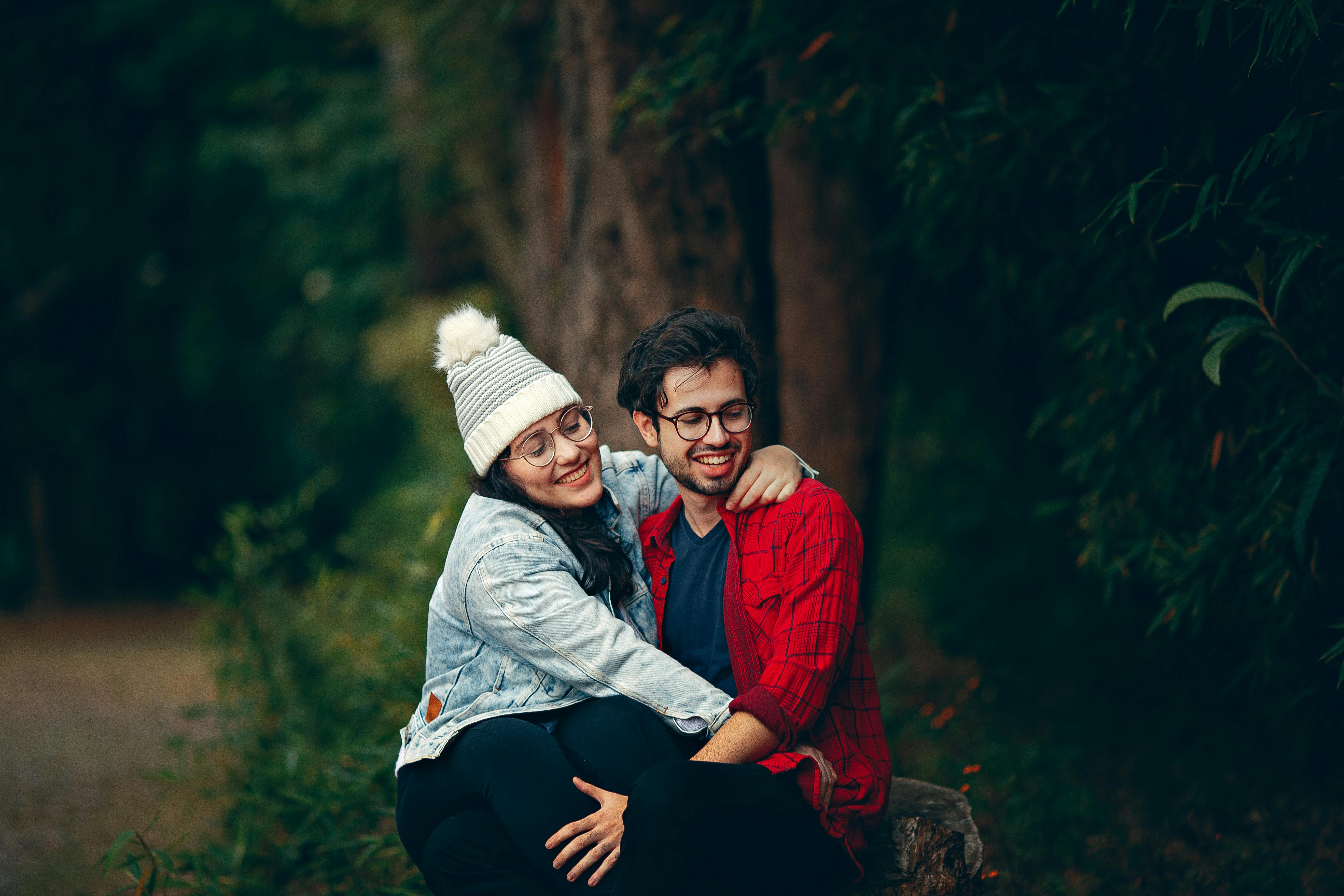 young couple in the woods admiring a freshly planted tree