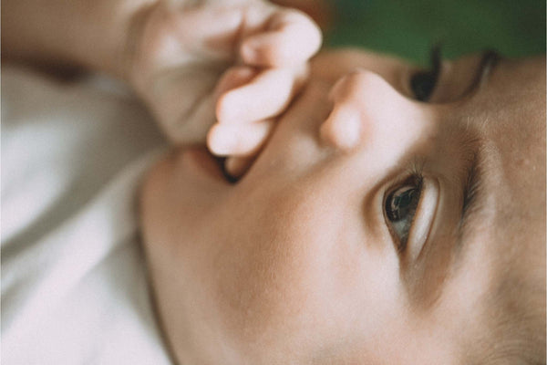 Baby chewing finger in his mouth