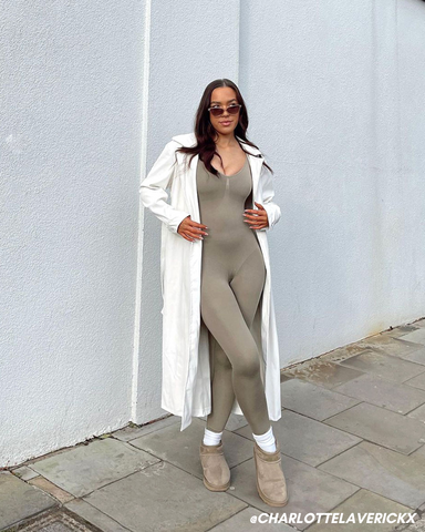 Female influencer in olive jumpsuit and trench coat