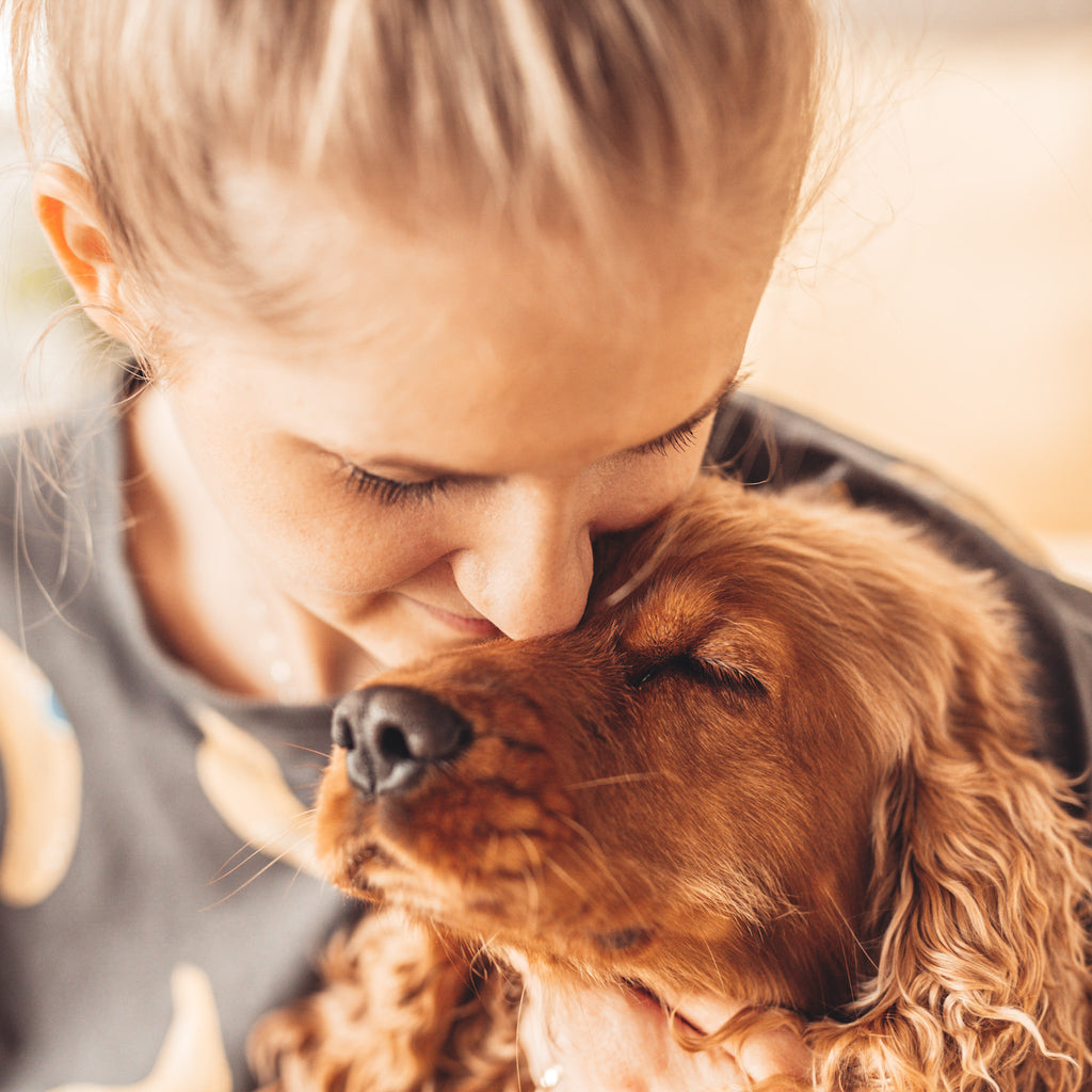 kobieta przytulająca psa - pomysł na prezent dla psiej mamy 