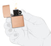 Classic Solid Copper Windproof Lighter lit in hand.