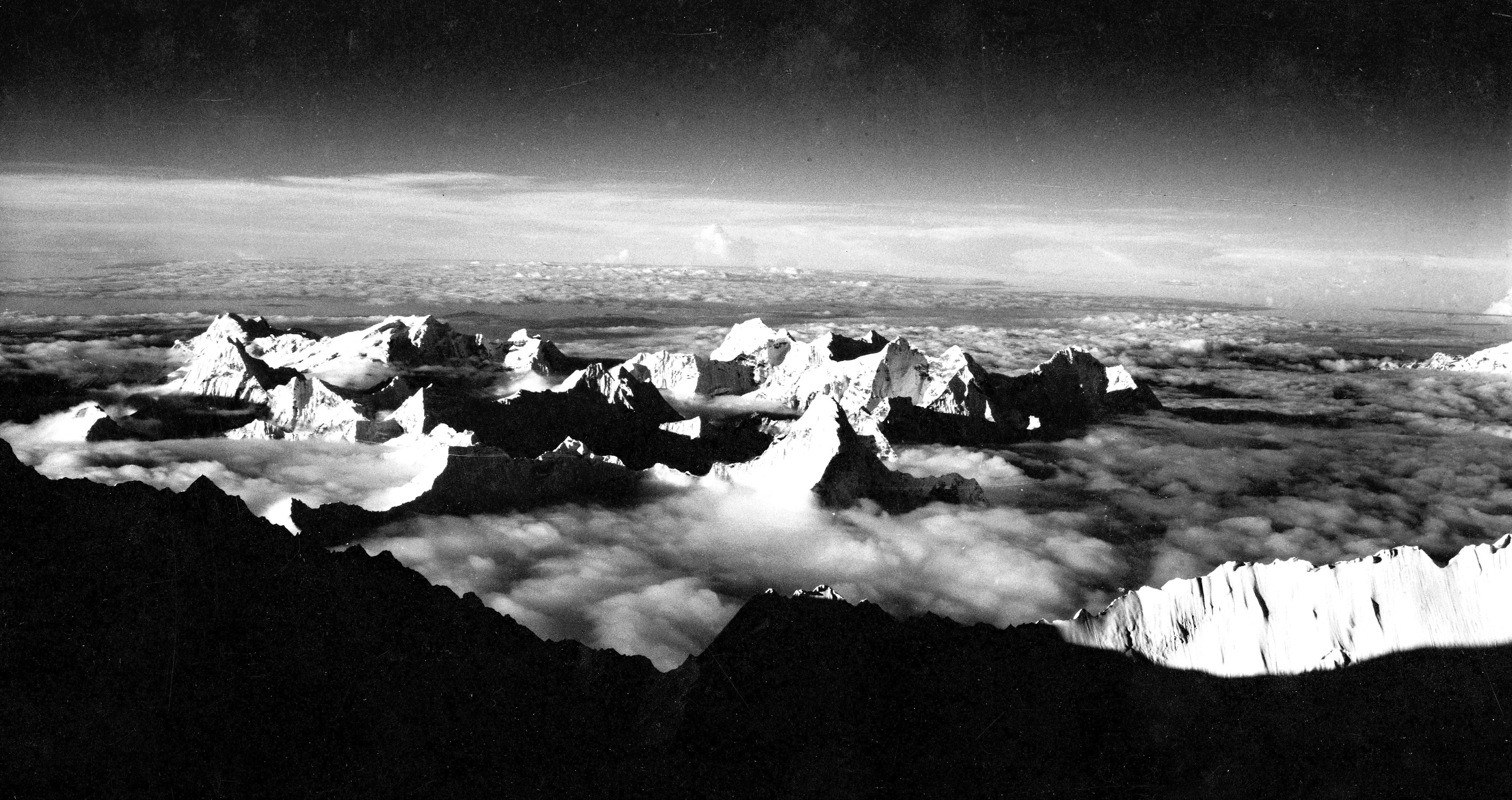 The view from the summit of Everest. Ama Dablam is poking out of the clouds in the centre, while the Nuptse-Lhotse ridge is partially shaded in the foreground.