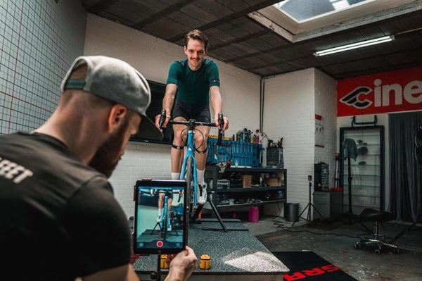 Cyclist on a bike being recorded by a professional bike fitter.