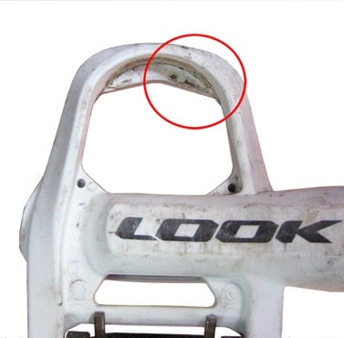 Closeup of a LOOK pedal with wear damage. A red circle highlights the spot in concern.