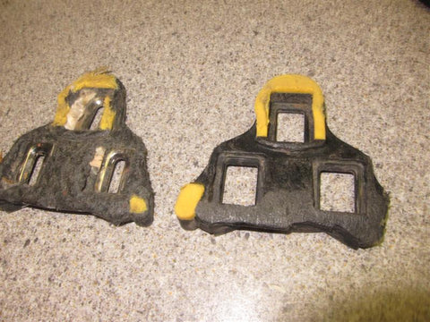 A pair of dirty and rusted cycling cleats laid flat