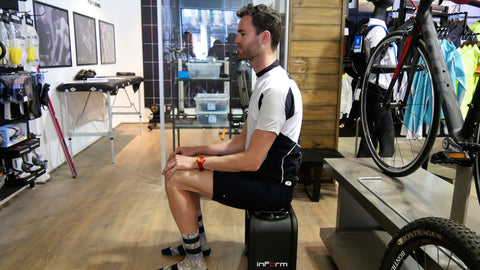 Cyclist shown from the side sitting on a sit bone measuring tool