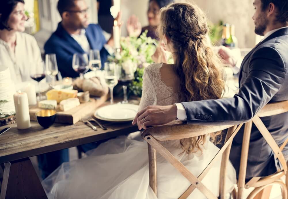back view of newlywed couple at wedding reception table