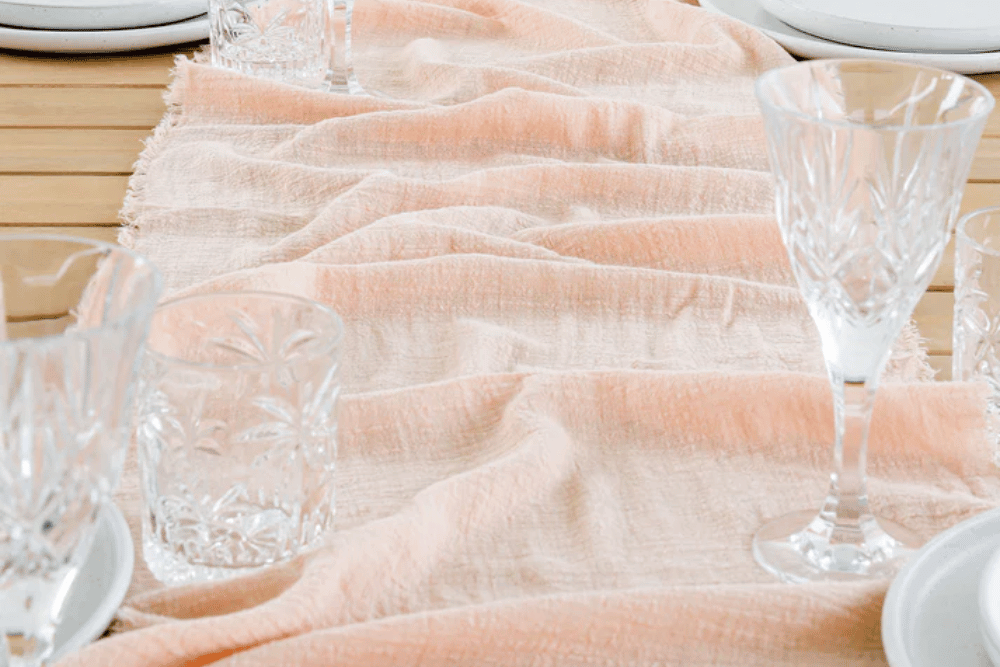blush pink gauze table cloth on wooden table