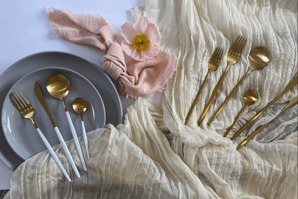 flat lay of table runner, cutlery, table napkin, and plates