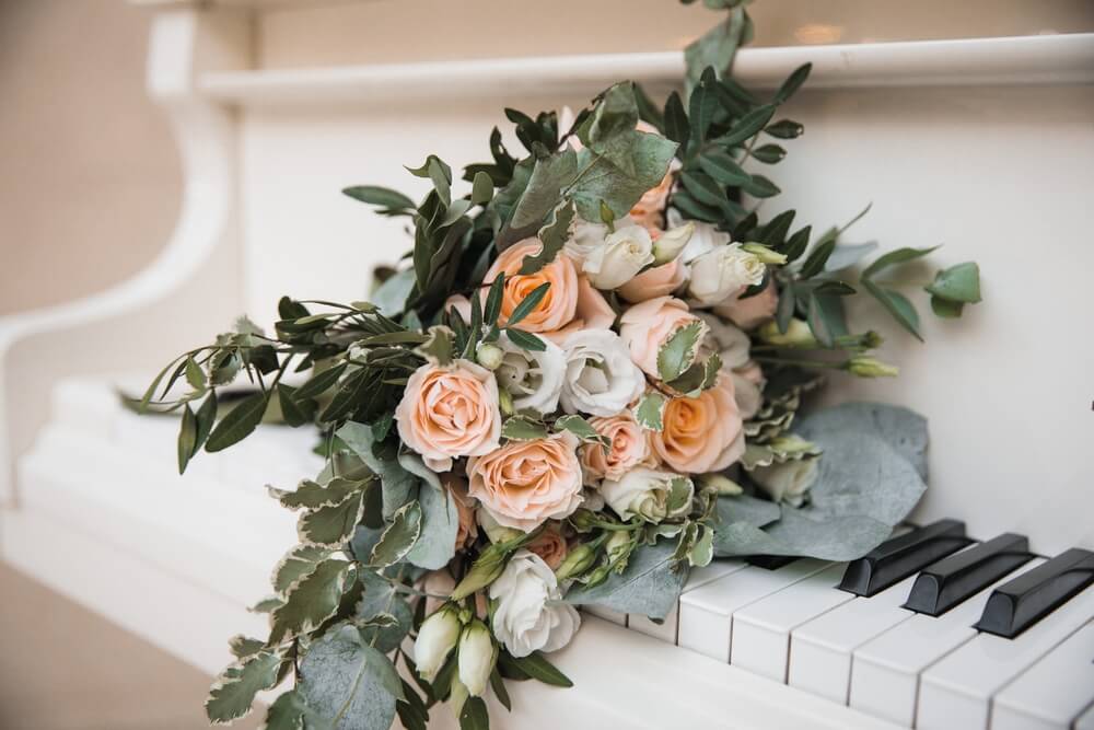 rustic bridal bouquet lies on the piano