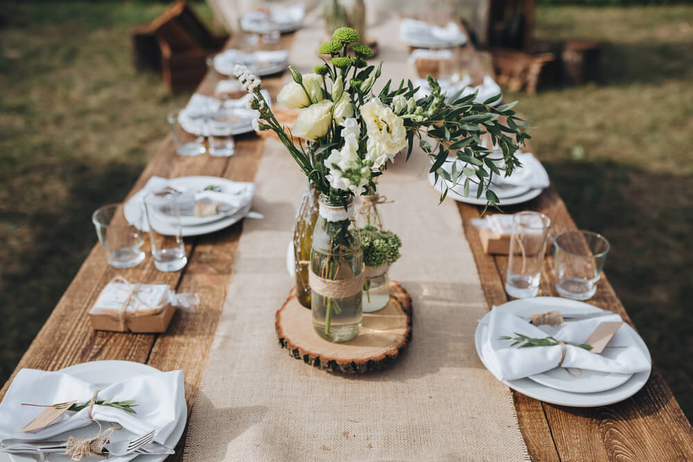 rustic wedding table with glass vases and flowers, linen table runner