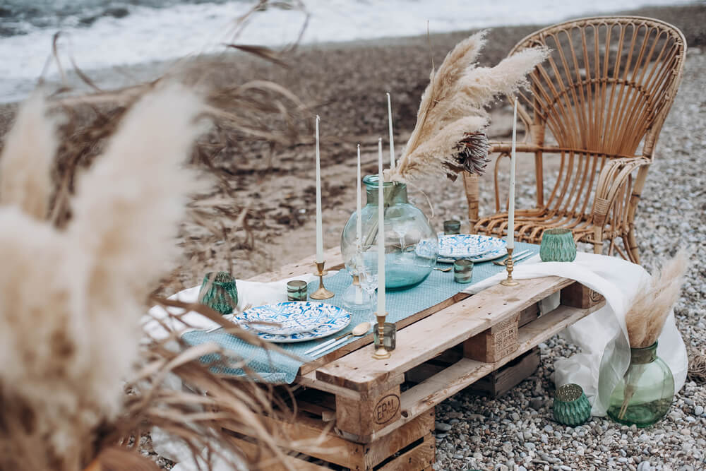 boho table setup on the beach with green elements and pampas grass