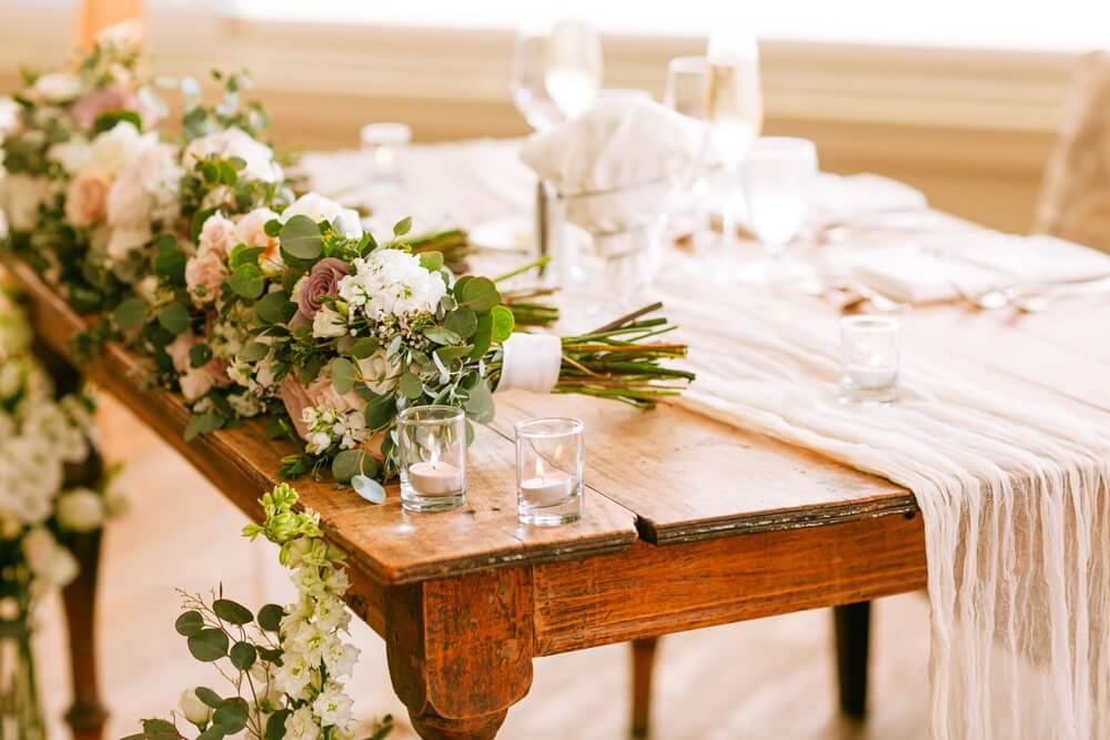 Classic tablescape with plain white runners and traditional flower arrangements