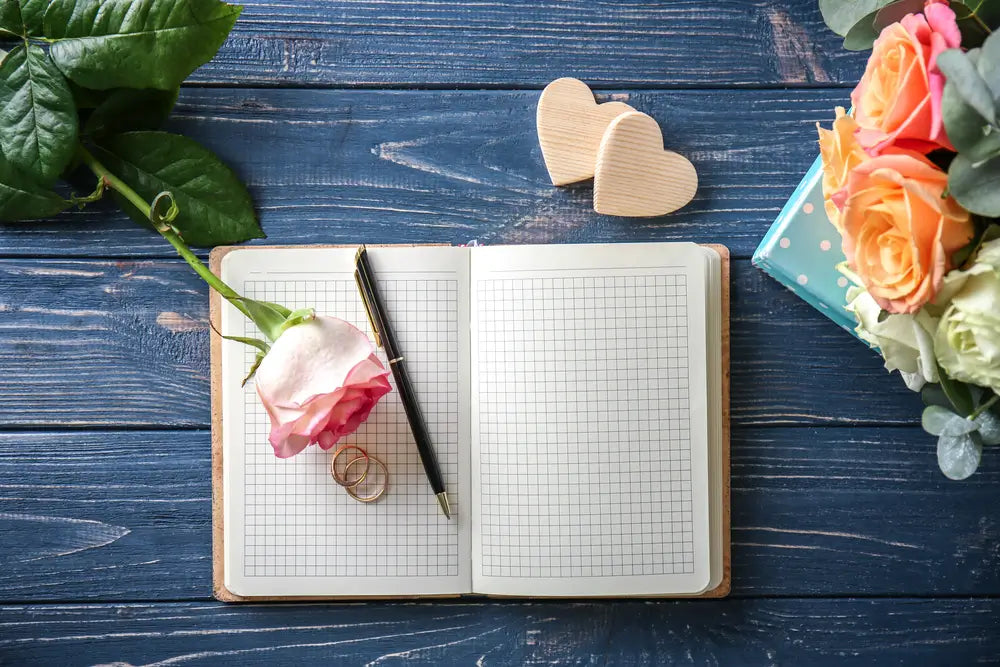 A notebook and pen for writing a wedding table decor checklist