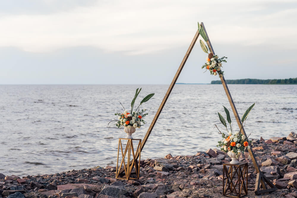 triangular boho-style wedding arch on the coast