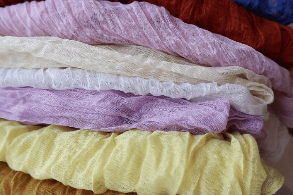 stack of folded gauze table runners in different colours