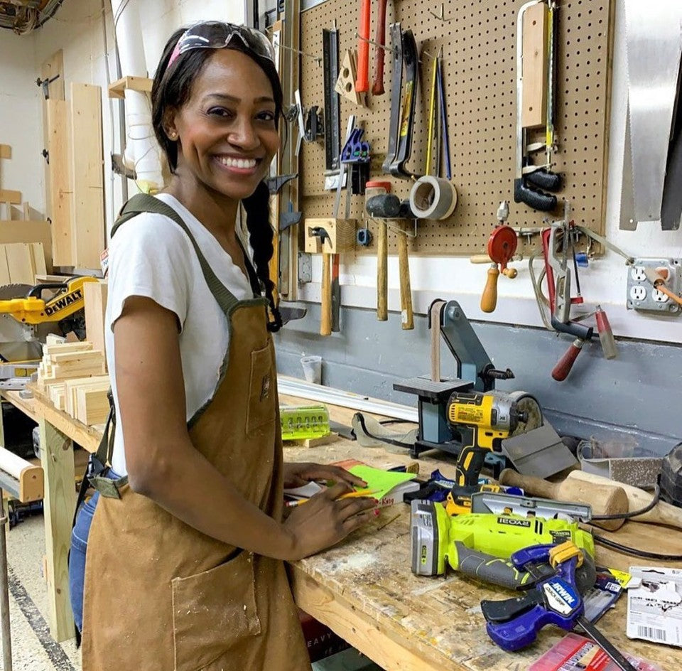 Char Miller-King stands next to workbench she built and tools