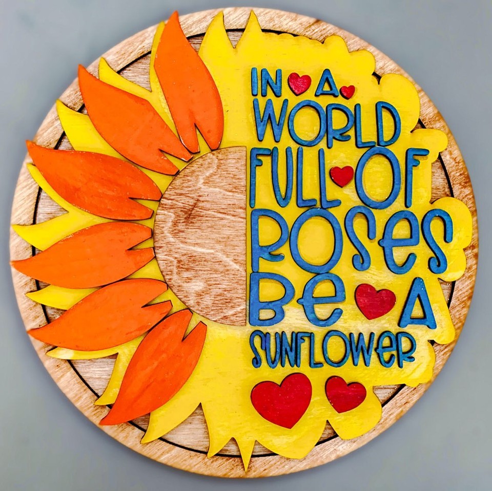 Wooden piece made by Char Miller-King that says "In a World Full of Roses, Be a Sunflower"