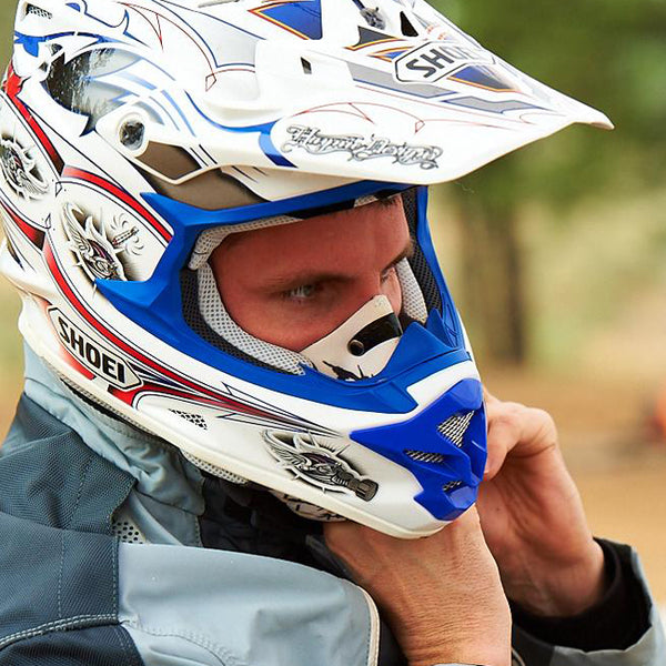 An individual wearing an ATV helmet and RZ mask for protection against dust and debris. The man appears to be outdoors and ready for adventure, with his protective gear on.